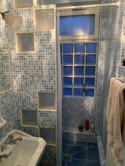 Salle d'eau en mosaïque bleue avec douche à l'italienne et pavés de verre